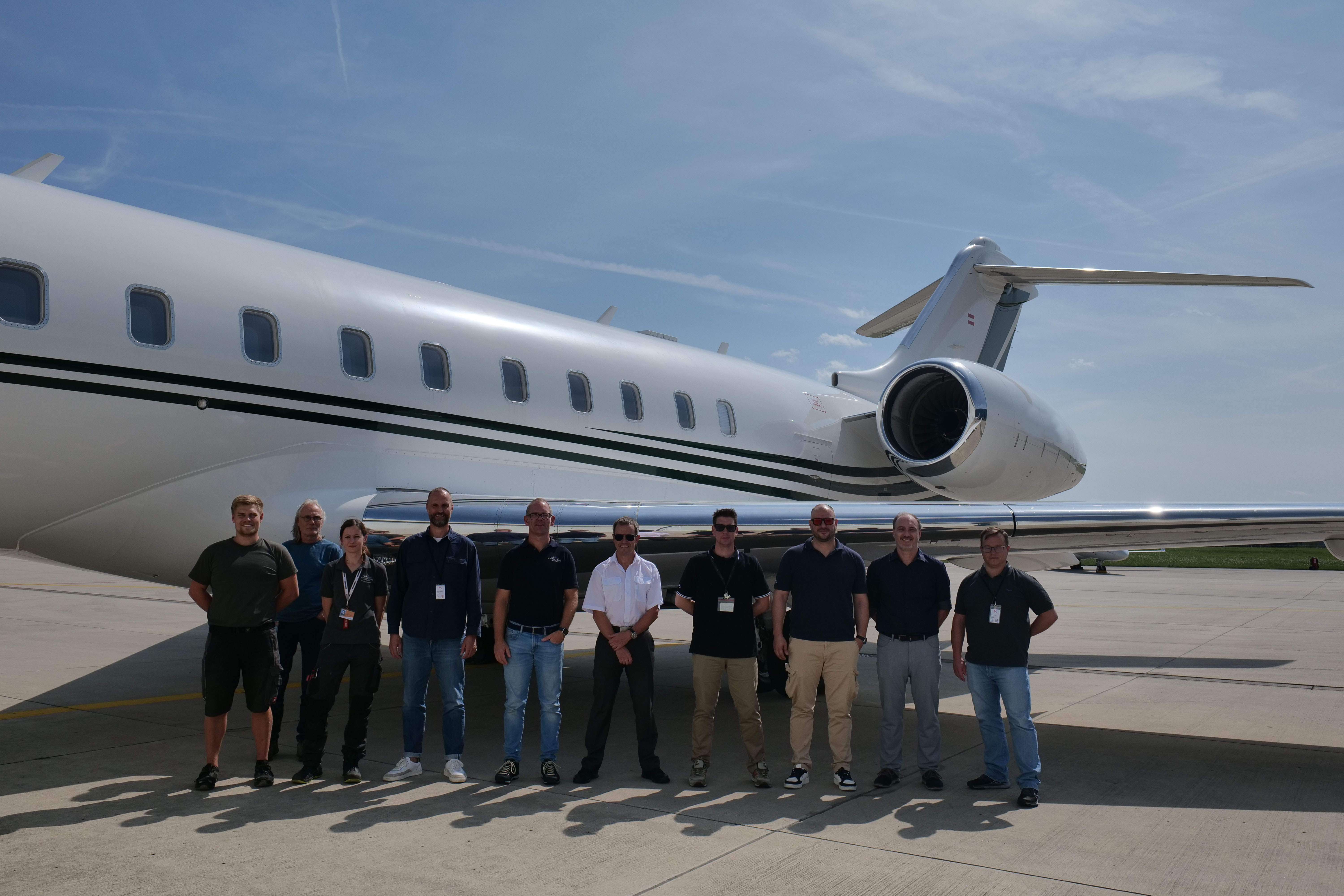 People standing in front of Bombardier Global jet with HDX antenna installed People standing in front of Bombardier Global jet with HDX antenna installed