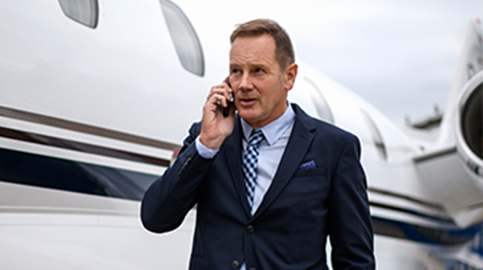 Man on phone standing next to plane