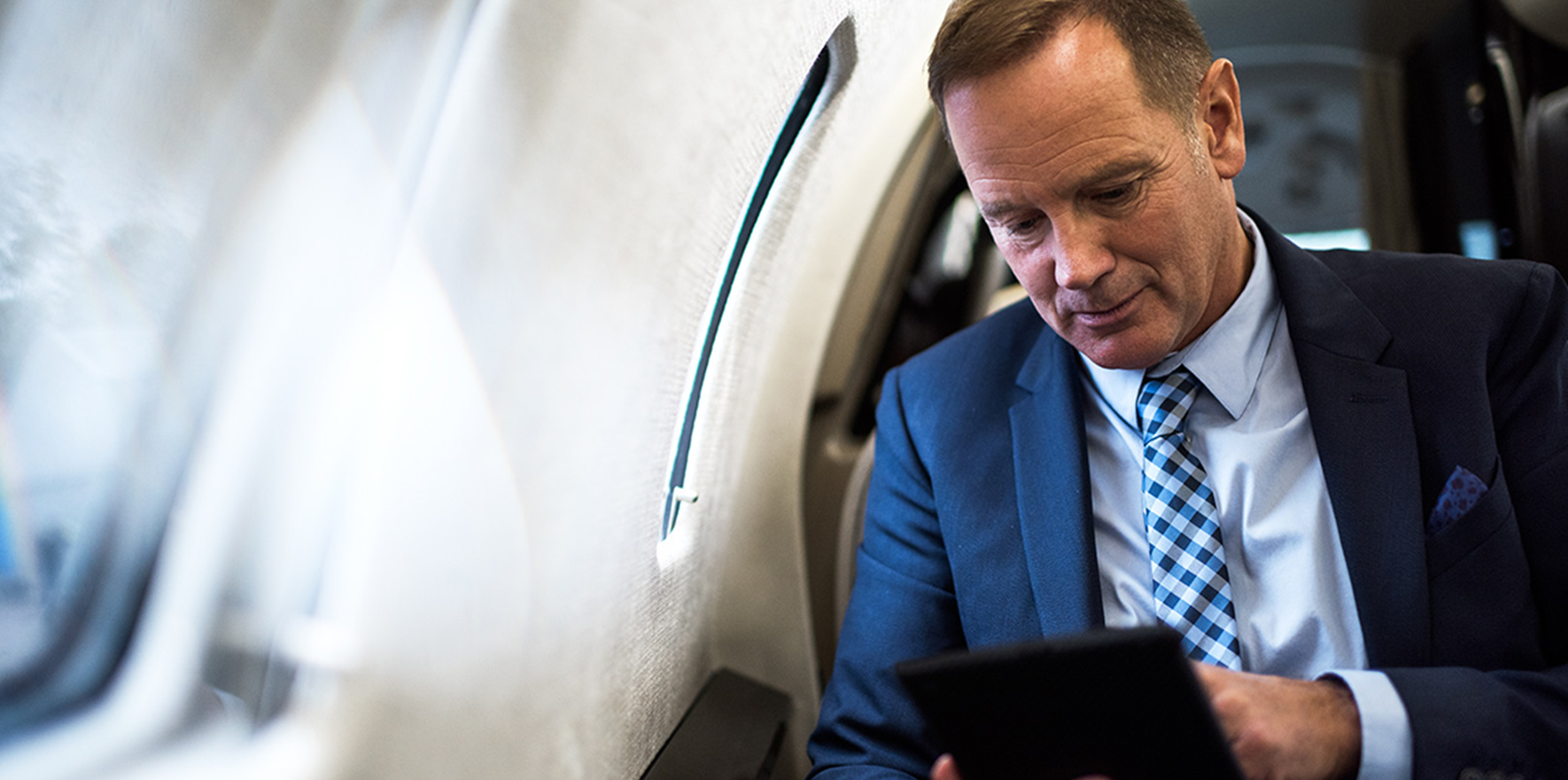 Executive using iPad in cabin
