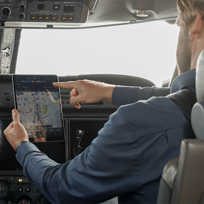 Pilot in cockpit looking at tablet 