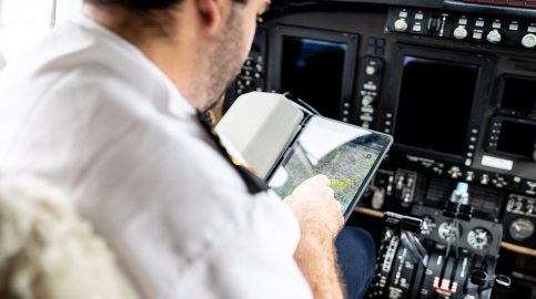 Piloto analisando mapas em tablet na cabine